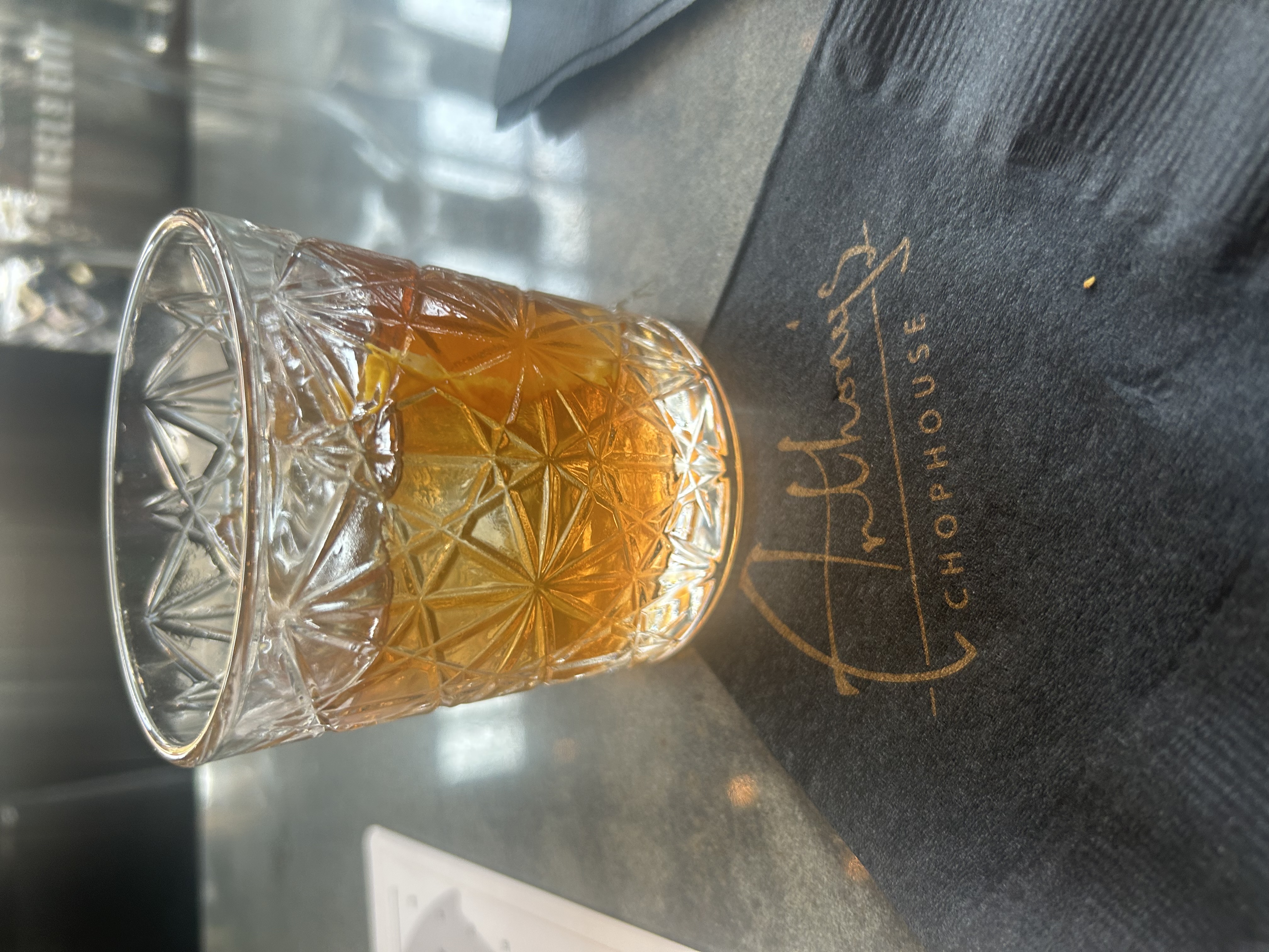 An Old Fashioned in a cut-crystal rocks glass on an Anthony's Chophouse coaster